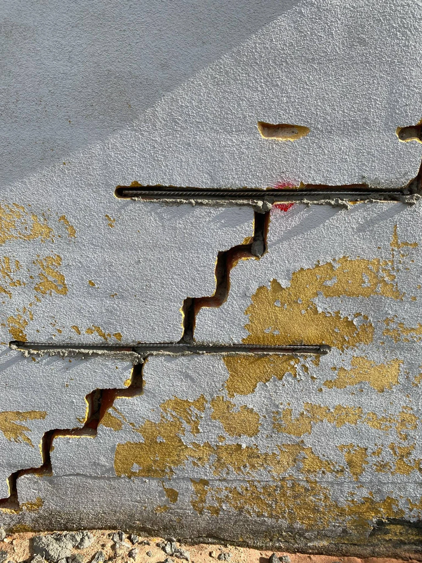 Væg med synlige revner og skallet maling, klar til reparation.
